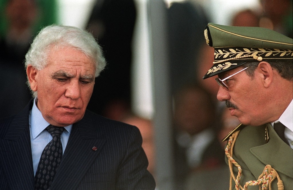Le général Khaled Nezzar (à droite) et le président algérien Chadli Bendjedid – lui aussi accusé, mais à tort, d’avoir fait partie de l’armée française –, à l’occasion du 35e anniversaire du déclenchement de la révolution algérienne de 1954, le 1er novembre 1989 à Alger (AFP)