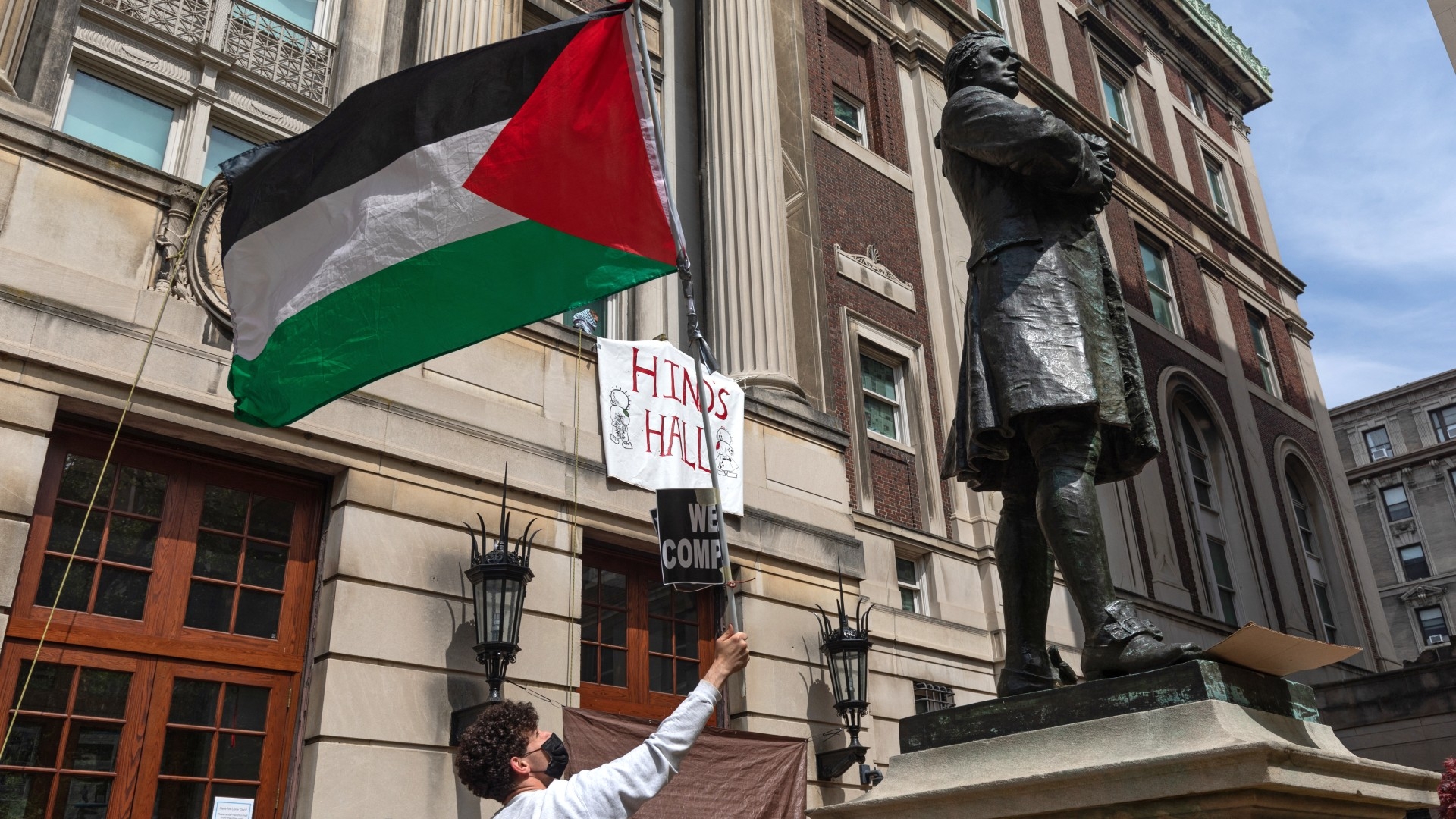 Pro-Palestinian student protestors wave a Palestinian flag as they gather on the front steps of Hamilton Hall at Columbia University in New York City on 30 April 2024 (AFP/Emily Byrski)