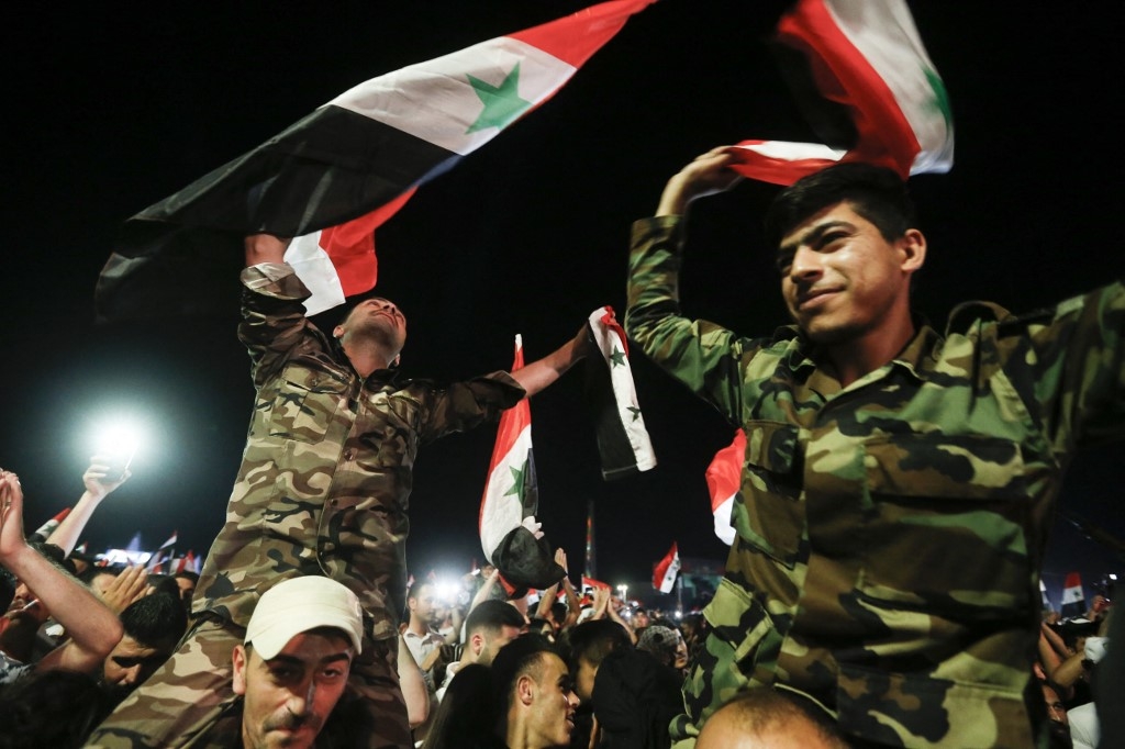 Des soldats syriens célèbrent la victoire du président Bachar al-Assad, qui remporte un quatrième mandat, à Damas, le 27 mai 2021 (AFP)