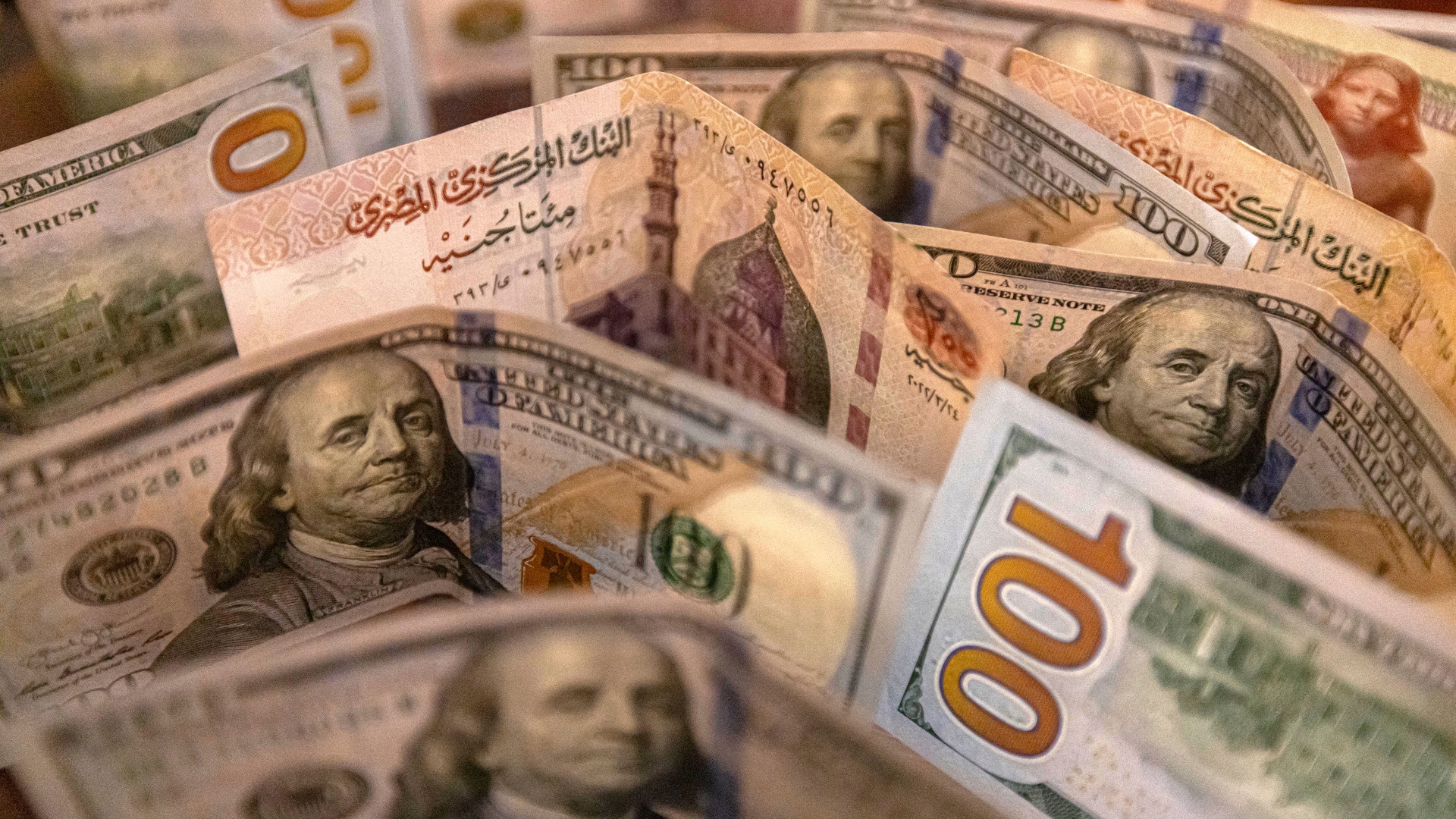 A picture taken on 15 August 2022 shows Egyptian pound and US dollar banknotes (AFP)