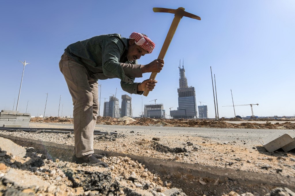 A workman digs with a pickaxe at a construction site at Egypt's "New Administrative Capital" megaproject, some 45 kilometres east of Cairo, on 7 March 2021 (AFP)