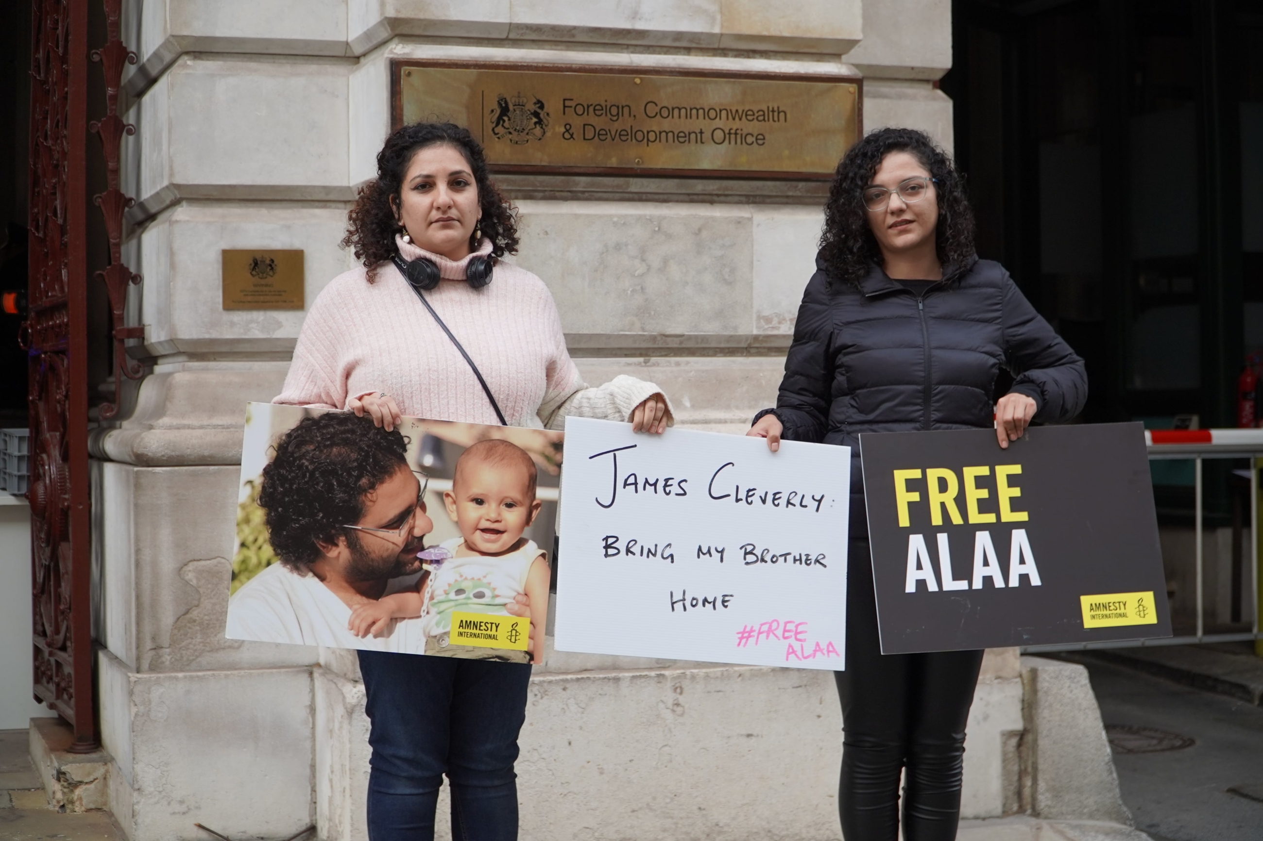 Mona Seif (L) and Sanaa Seif (R), sisters of Alaa Abdel Fattah, protest outside the British foreign office in London on 19 October 2022 (MEE/Khaled Shalaby)