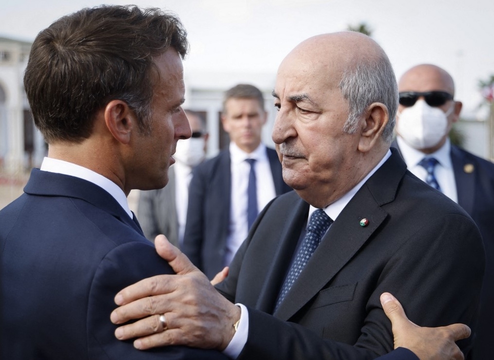 Le président français Emmanuel Macron (à gauche) salue le président algérien Abdelmadjid Tebboune (à droite) à son arrivée à l'aéroport d’Alger, le 27 août 2022 (AFP/Ludovic Marin)