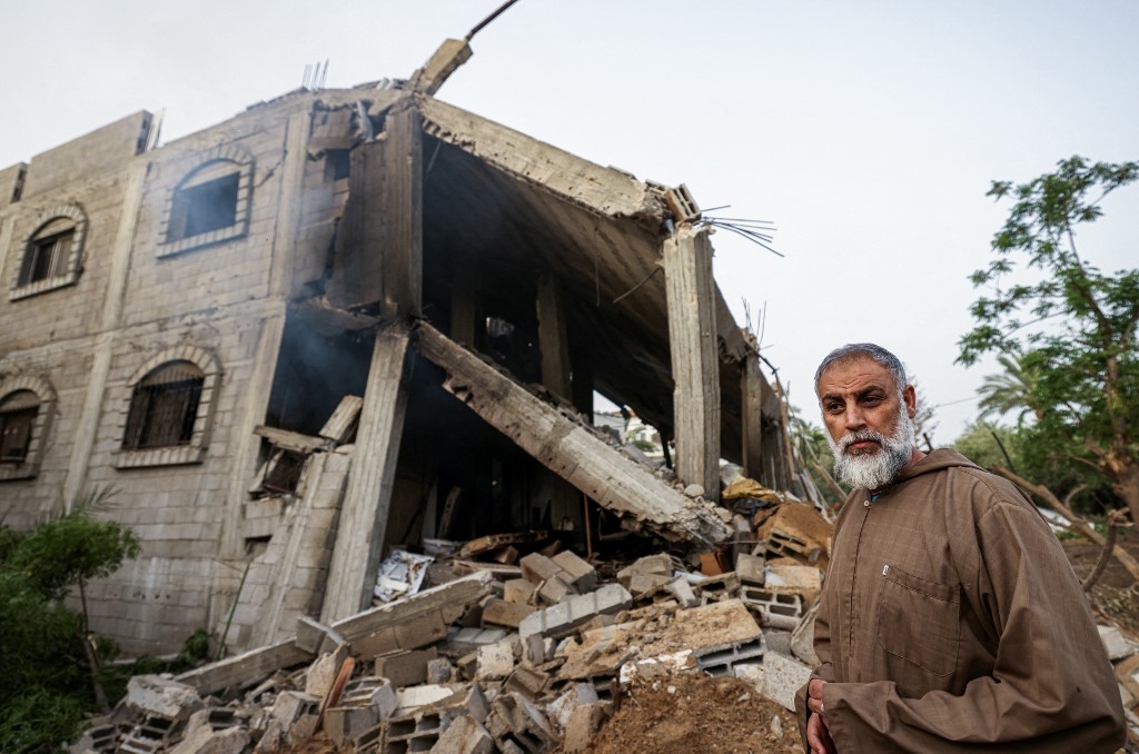 Un Palestinien regarde les décombres d’un bâtiment à la suite d’une frappe aérienne israélienne à Deir el-Balah, dans le centre de la bande de Gaza, le 12 mai 2023 (AFP/Mahmoud Hams)