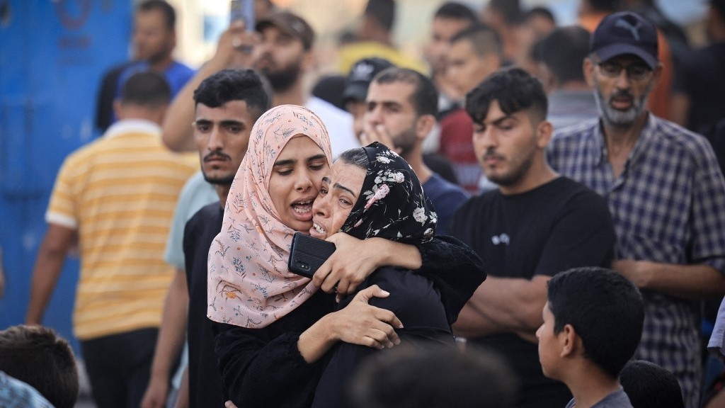 In this file photo, Palestinian women react after an Israeli strike near an Unrwa school in Khan Yunis, in the southern Gaza Strip on 21 October 2023 (AFP)