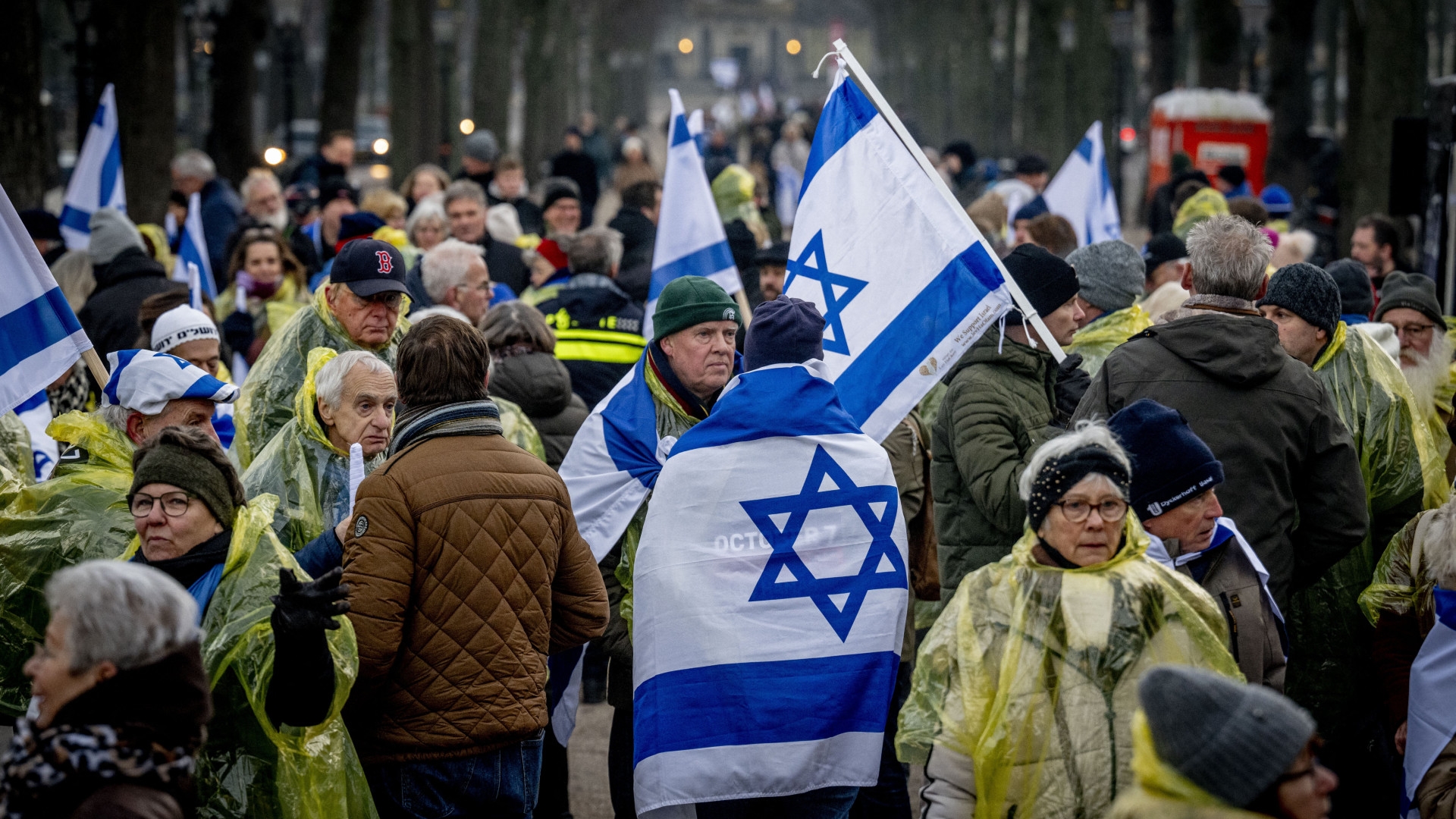 Protesters wave Israeli flags during a demonstration against the hearing at the International Court of Justice (ICJ) on a genocide complaint by South Africa against Israel, in The Hague, Netherlands, on 11 January 2024 (Robin Utrecht/AFP)