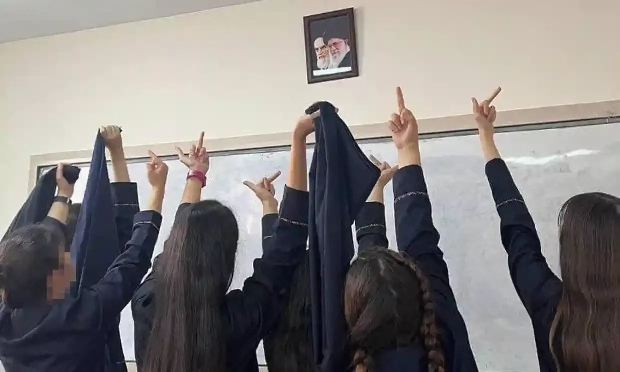 Schoolgirls are gesturing against Iran's Supreme Leader Khamenei's portrait in protests