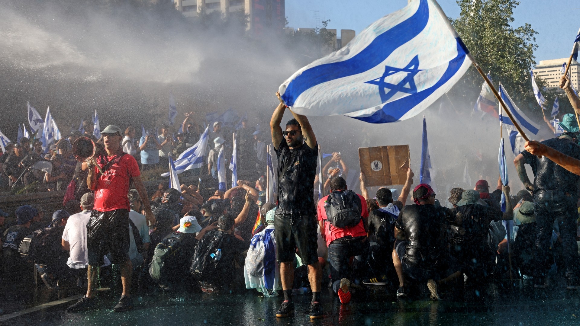 Israeli forces use a water cannon to disperse demonstrators blocking the entrance of the Knesset, Israel's parliament, in Jerusalem on 24 July 2023 (AFP)