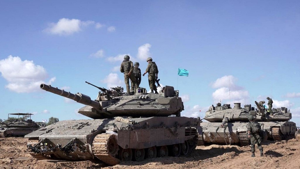 This handout picture released by the Israeli army on May 10, 2024 reportedly shows Israeli soldiers standing atop a main battle tank as part of the Givati Brigade operating in eastern Rafah in the southern Gaza Strip (AFP)