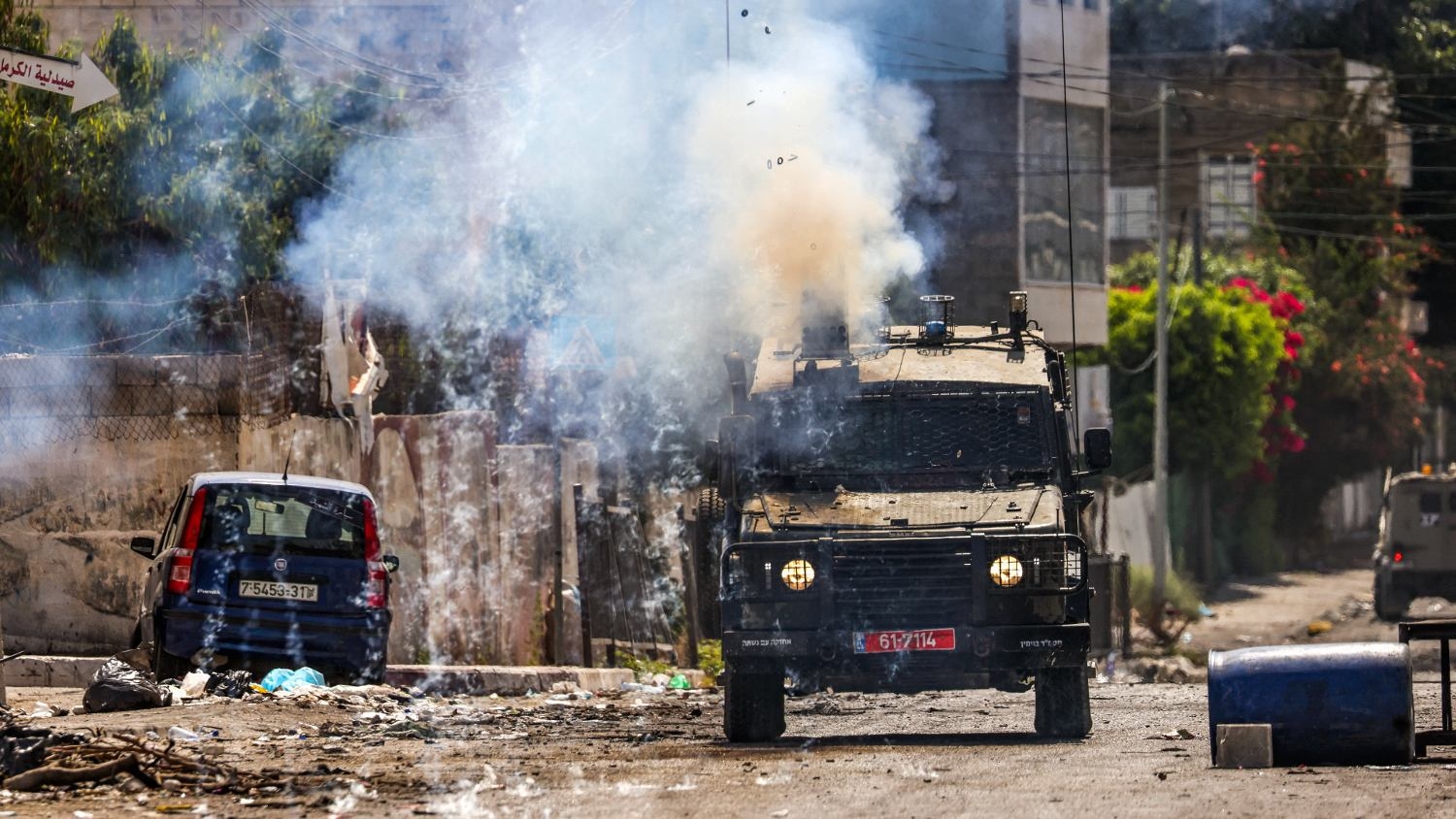 Israeli soldiers fire tear gas canisters from an armoured vehicle during an ongoing military operation in the occupied West Bank city of Jenin on 4 July 2023.