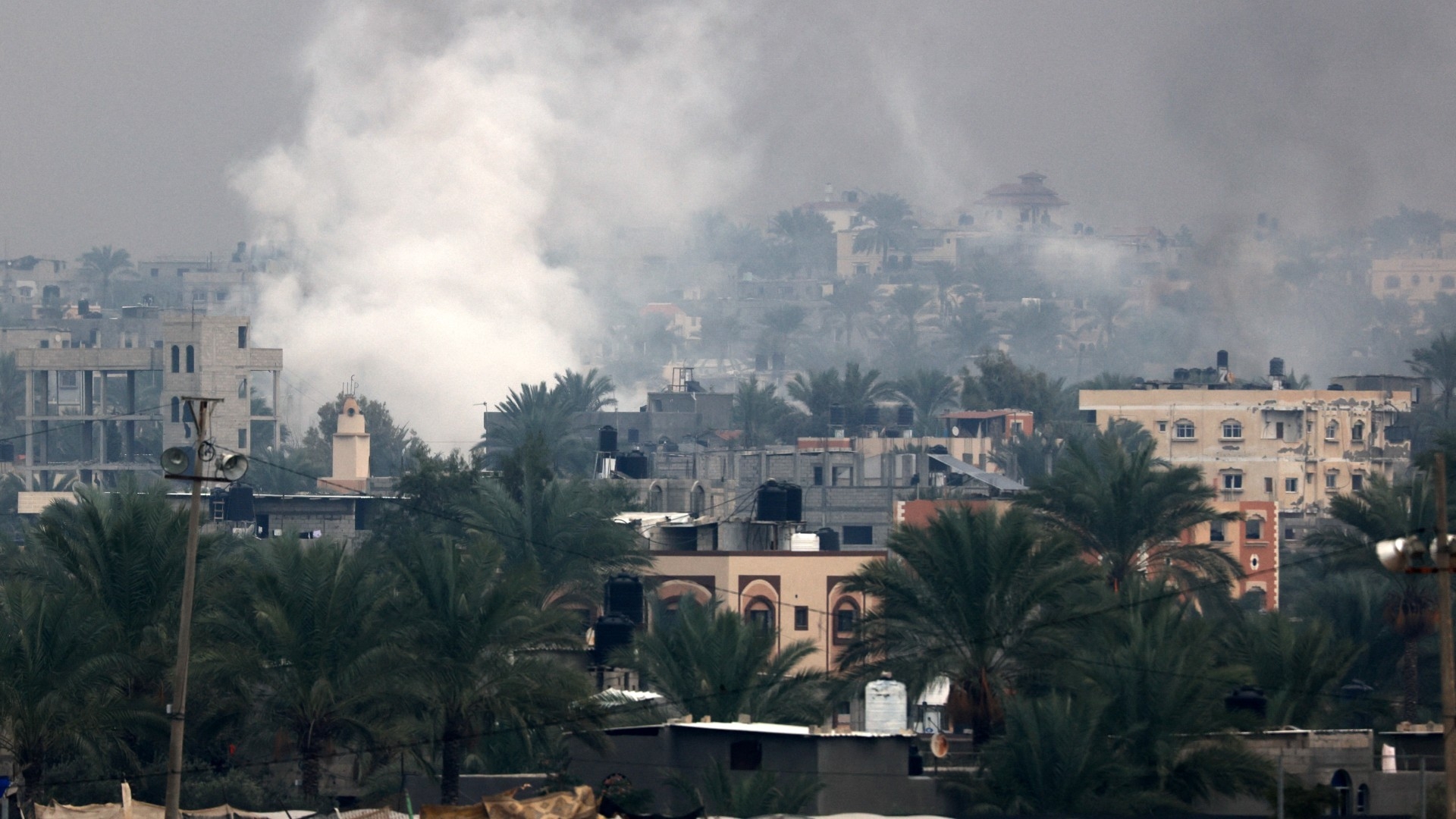 Smoke rises above buildings in Khan Younis in the southern Gaza Strip on 5 December 2023 (AFP)