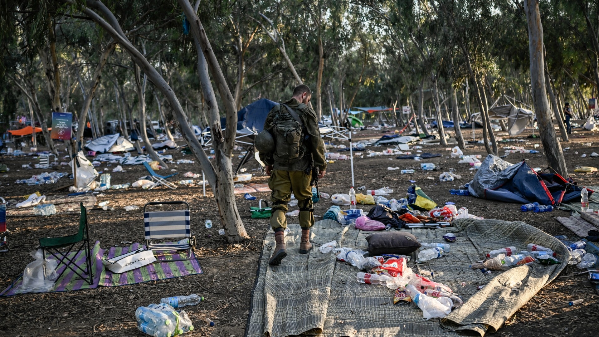 An Israeli soldier patrols near Kibbutz Beeri in southern Israel on 12 October 2023, close to where revellers were killed by Hamas fighters during the Supernova music festival (Aris Messinis/AFP)