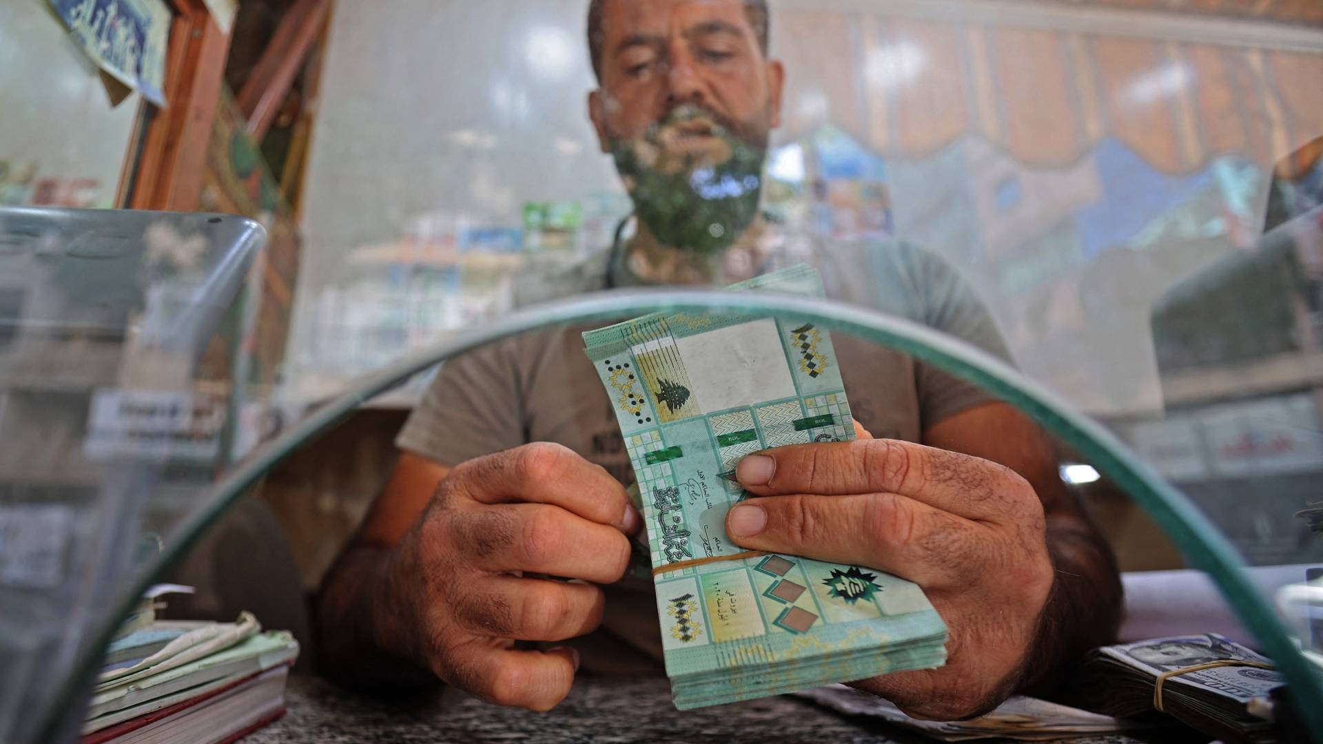 A money changer counts Lira notes at his shop in Beirut's Lebanese capital, 22 September 2022 (AFP)
