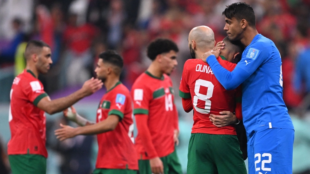 Morocco's goalkeeper Ahmed Reda Tagnaouti comforts midfielder Azzedine Ounahi at the end of the World Cup semi-final between France and Morocco on 14 December 2022.