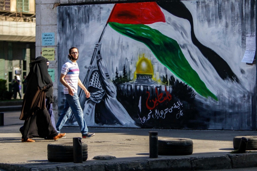 A mural reads “Palestine will remain, from the river to the sea” 