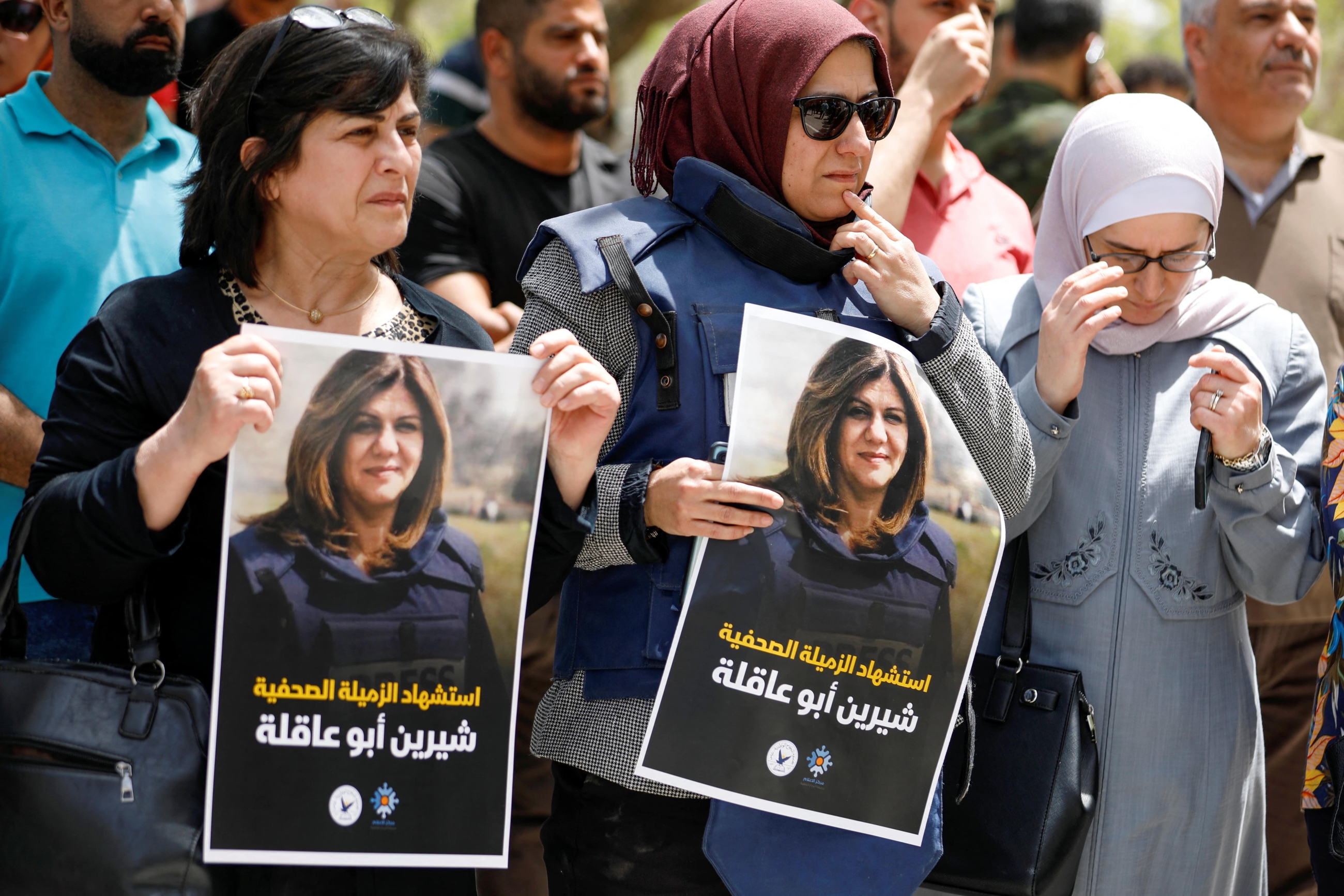 Palestinians hold pictures of Al Jazeera reporter Shireen Abu Akleh, who was killed by Israeli army gunfire during an Israeli raid, according to the Qatar-based news channel, in Nablus in the Israeli-occupied West Bank 11 May 2022 (Reuters)
