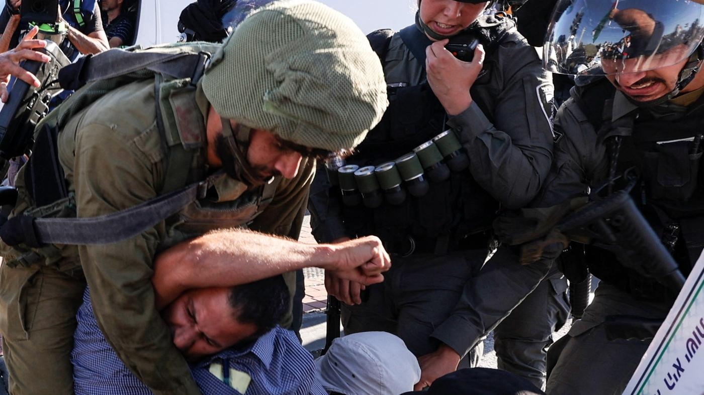 Des membres des forces de sécurité israéliennes arrêtent un homme lors d’une manifestation contre l’expansion des colonies, dans la ville de Cisjordanie occupée Salfit, le 27 juillet 2022 (AFP)