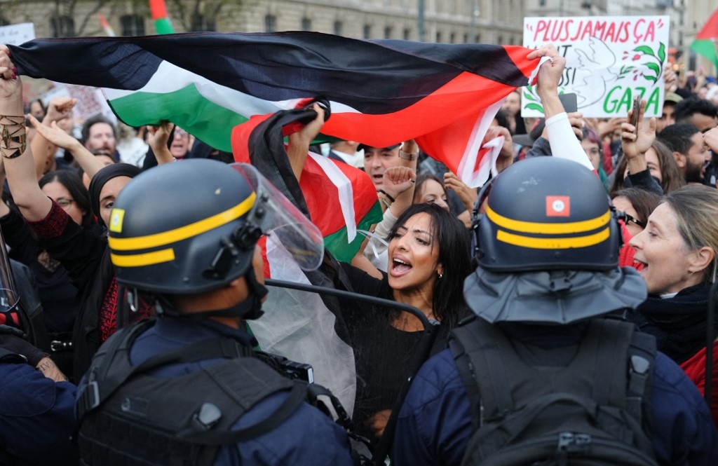 Des manifestants face aux CRS lors d’une manifestation de soutien aux Palestiniens sur la place de la République, à Paris, le 19 octobre 2023 (AFP)
