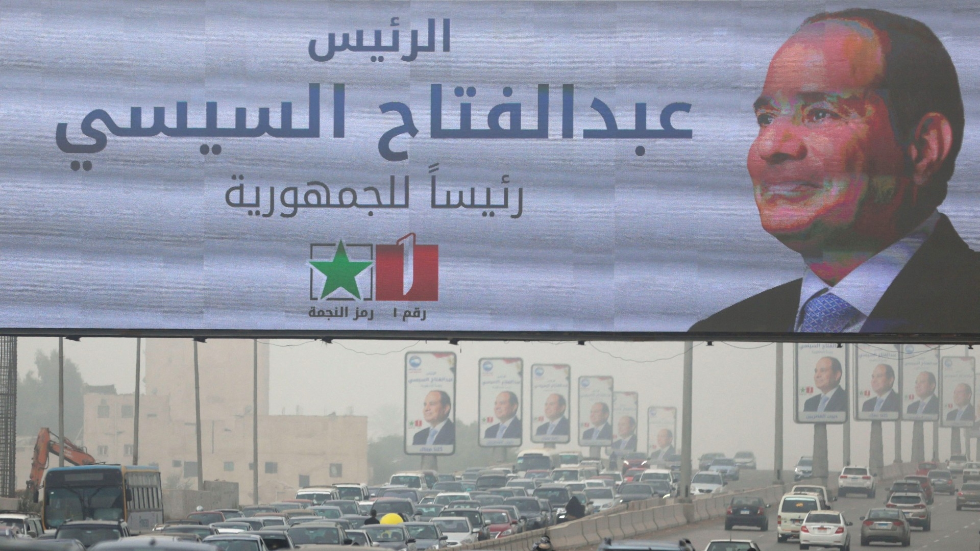 Vehicles drive past a banner and posters of presidential candidate and current Egyptian President Abdel Fattah al-Sisi ahead of the presidential elections to be held inside the country next week, in Cairo, Egypt, December 5, 2023.