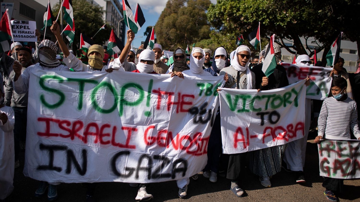 Demonstrators hold banners and Palestinian flags as they march through the city centre in Cape Town, on 12 May 2021 during a protest against Israeli attacks on Palestinians in Gaza.