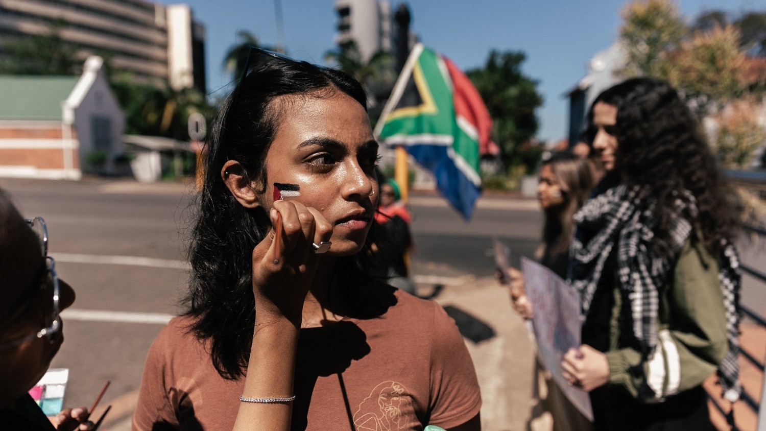 A young activist gets her face painted with a Palestinian flag during a demonstration in support of Palestine in Durban on 13 October 2023.