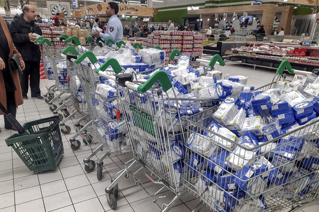 Cette photo, prise le 12 janvier 2023, montre des chariots remplis de briques de lait dans un supermarché de Tunis, où le rationnement est imposé à deux briques de lait par personne au milieu d'une pénurie de café, lait, pâtes et sucre (AFP/Fethi Belaïd)
