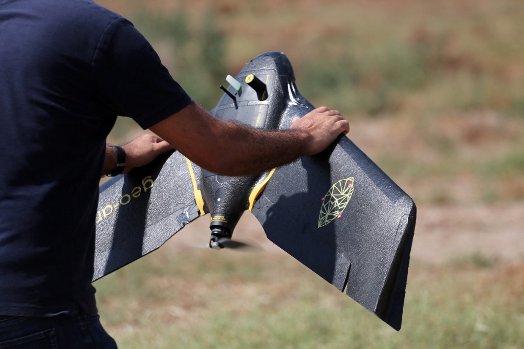 Un technicien de la startup RoboCare s’apprête à survoler un domaine agricole avec un drone, pour scanner les arbres depuis les airs et évaluer leur niveau d’hydratation, la qualité des sols et leur état de santé général, afin de prévenir des dommages irréversibles, dans la région de Nabeul, au sud-ouest de Tunis, le 30 août 2023 (AFP)
