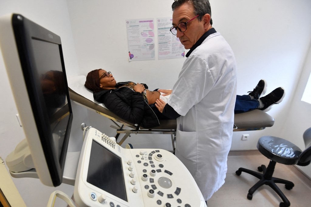 Le médecin tunisien et professeur de gynécologie Fethi Zhiwa, spécialisé dans l’infertilité, examine une patiente dans une clinique de Tunis, le 6 décembre 2023 (AFP/Fethi Belaïd)