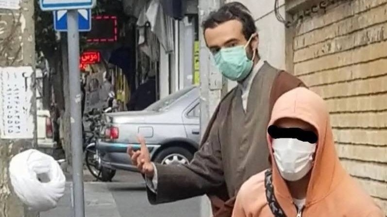 A man knocks the turban off an Iranian cleric (social media)
