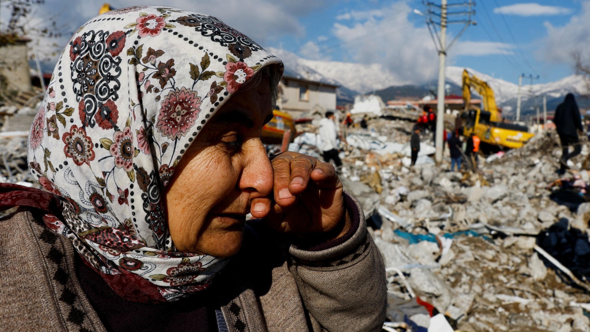 A women reacts as she stands near rubble and damages following an earthquake in Gaziantep, Turkey, 7 February 2023 (Reuters)