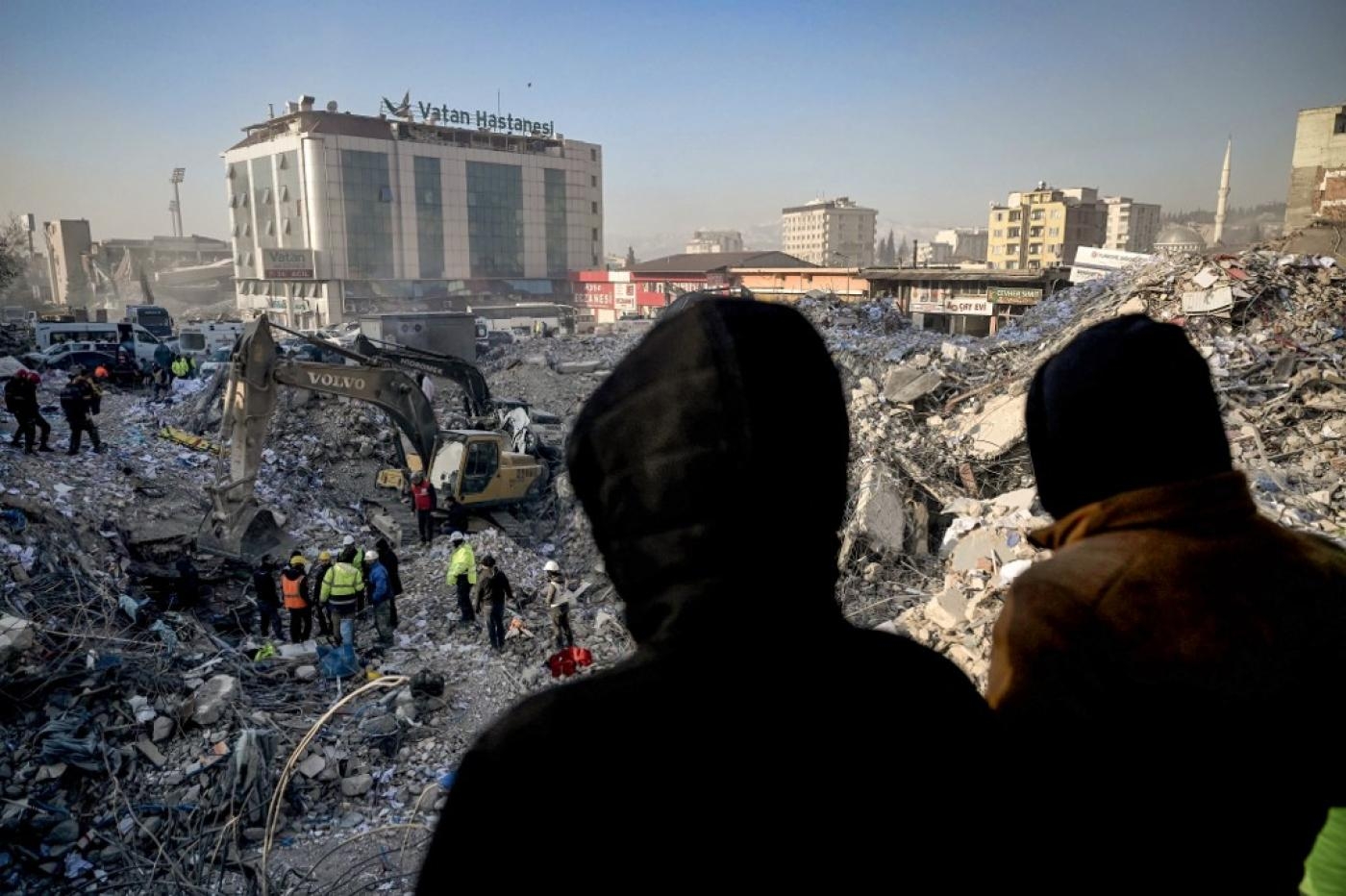 Des gens attendent des nouvelles de leurs proches alors que les équipes de secours fouillent les décombres à Kahramanmaraş, en Turquie, le 14 février 2023 (AFP)