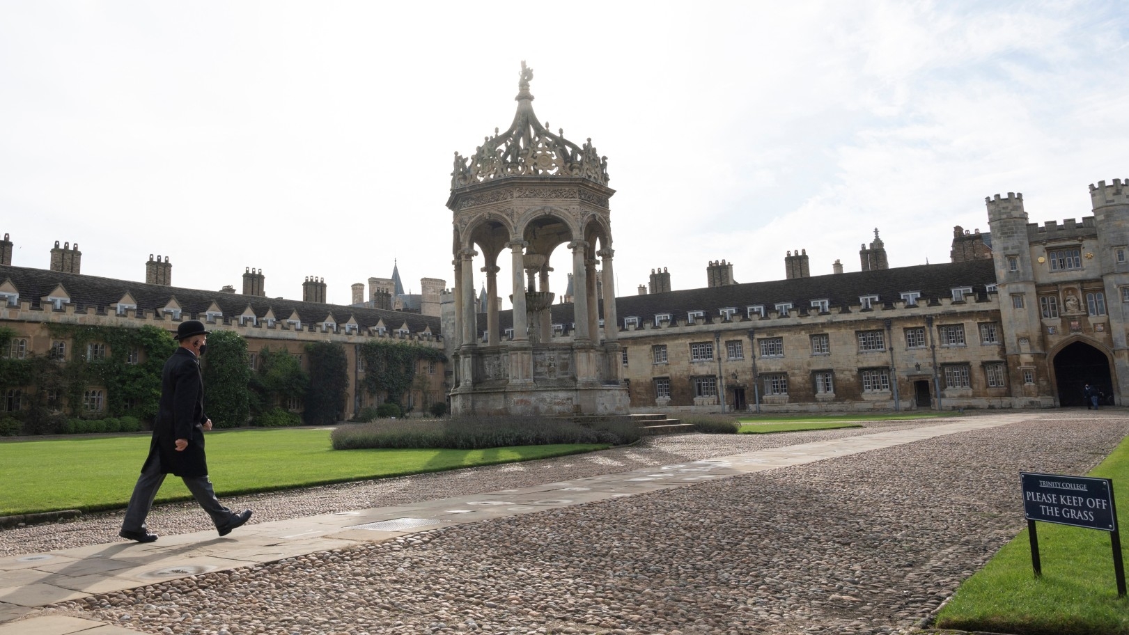 A porter walks across the Great Court at Trinity College, part of the University of Cambridge, on 14 October 2020 (AFP)