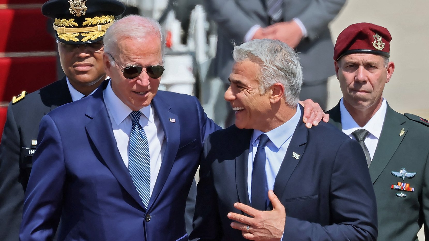 US President Joe Biden is welcomed by Israeli caretaker Prime Minister Yair Lapid upon his arrival at Ben Gurion Airport in Lod near Tel Aviv, on 13 July 2022.