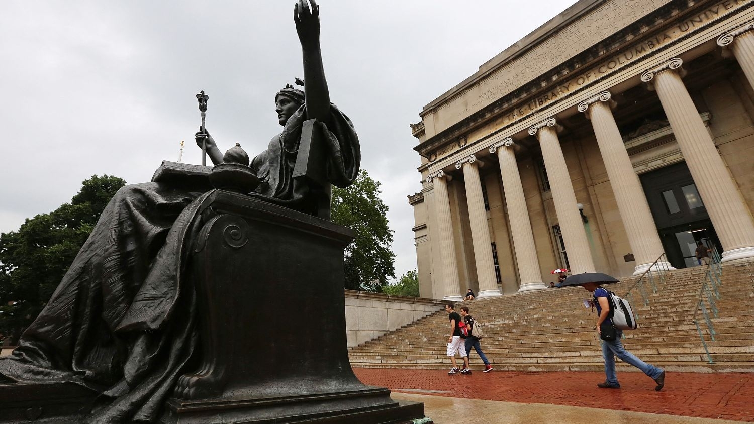 People walk past the Alma Mater statue on the Columbia University campus on 1 July 2013 in New York City.