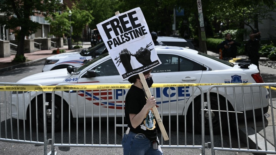 A demonstrator holds a sign after police cleared a pro-Palestinian student protest encampment in Washington on 8 May 2024 (Brendan Smialowski/AFP)