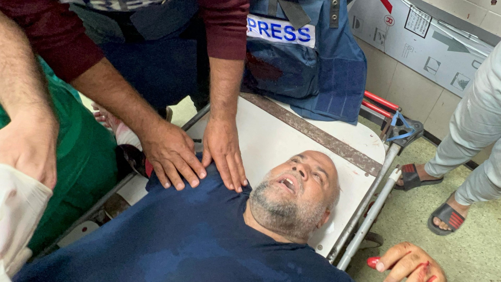 Al-Jazeera correspondent Wael Al-Dahdouh receives medical care in Khan Younis in the southern Gaza Strip on 15 December 2023 after being wounded by an Israeli air strike (AFP)