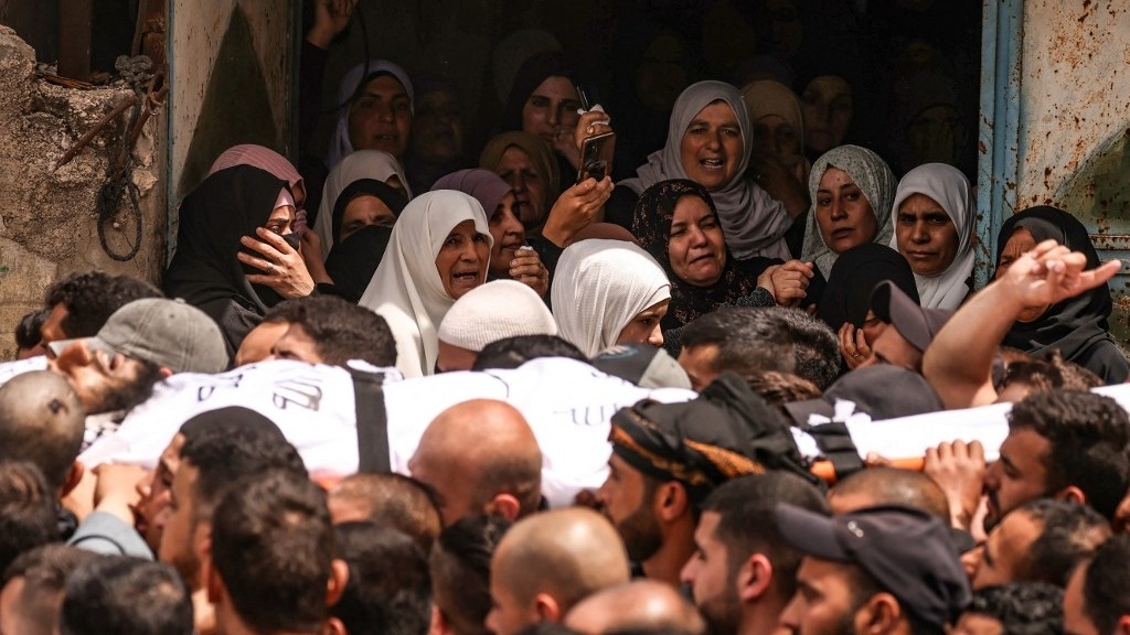 Women react as Mourners carry the body of one of two Palestinian men, days after they were killed during an Israeli settlers' attack on the village of Aqraba in the Israeli-occupied West Bank, during their funeral procession on 20 April 2024 (AFP)