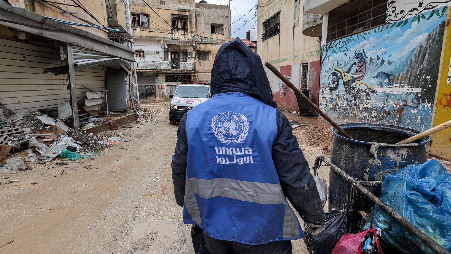 Un homme porte une veste de l’UNRWA à Jénine, en Cisjordanie occupée, le 30 janvier 2024 (AFP)