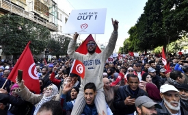 Des manifestants tunisiens brandissent des pancartes lors d’une manifestation dans le centre de Tunis contre leur président le 14 janvier 2023 (AFP/Fethi Belaid)