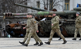 Des officiers ukrainiens passent devant des véhicules militaires russes détruits présentés dans une exposition en plein air à Kyiv, le 27 février 2023 (AFP)