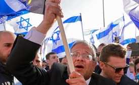 Le législateur israélien d’extrême droite Itamar Ben-Gvir brandit un drapeau israélien sur la place Safra de Jérusalem au début d’une « marche des drapeaux », le 20 avril 2022 (AFP)