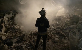 Un membre des Casques blancs se tient devant les décombres d’un immeuble lors de la recherche de survivants dans la ville syrienne tenue par les forces antigouvernementales de Jaindairis, le 8 février 2023 (AFP)