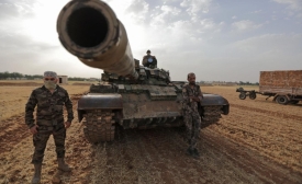  Des combattants syriens, soutenus par la Turquie, autour d’un char lors d’un exercice militaire dans la campagne de Manbij, en Syrie, le 2 juin 2022 (AFP)