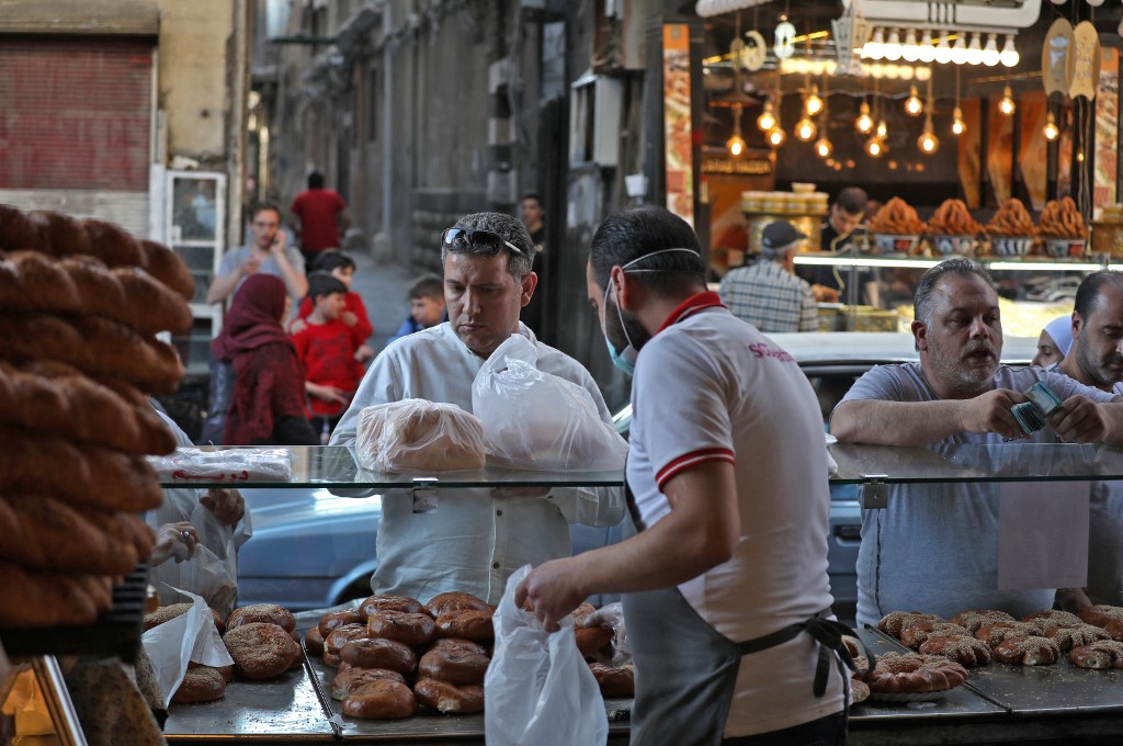 Syrians buy traditional sweet bread in Damascus on 27 April 2021 (AFP)