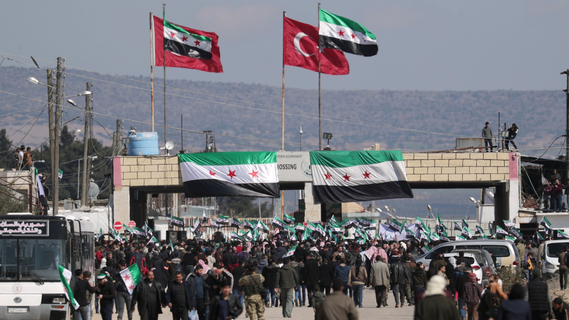 Internally displaced Syrians hold Syrian opposition flags during a protest in support of the Turkish army and Turkey backed Syrian rebels at the Bab el-Salam border crossing between the Syrian town of Azaz and the Turkish town of Kilis, in Syria, February 25, 2020.
