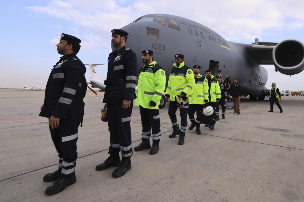 Rescue workers disembark from a military aircraft carrying them and equipment from the United Arab Emirates upon its arrival at the Damascus International airport on February 9, 2023