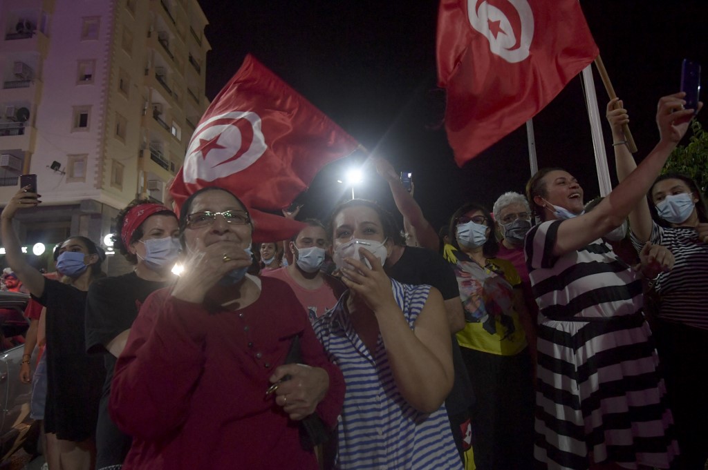 People celebrate in Tunis after Saied suspends parliament on 25 July 2021 (AFP)