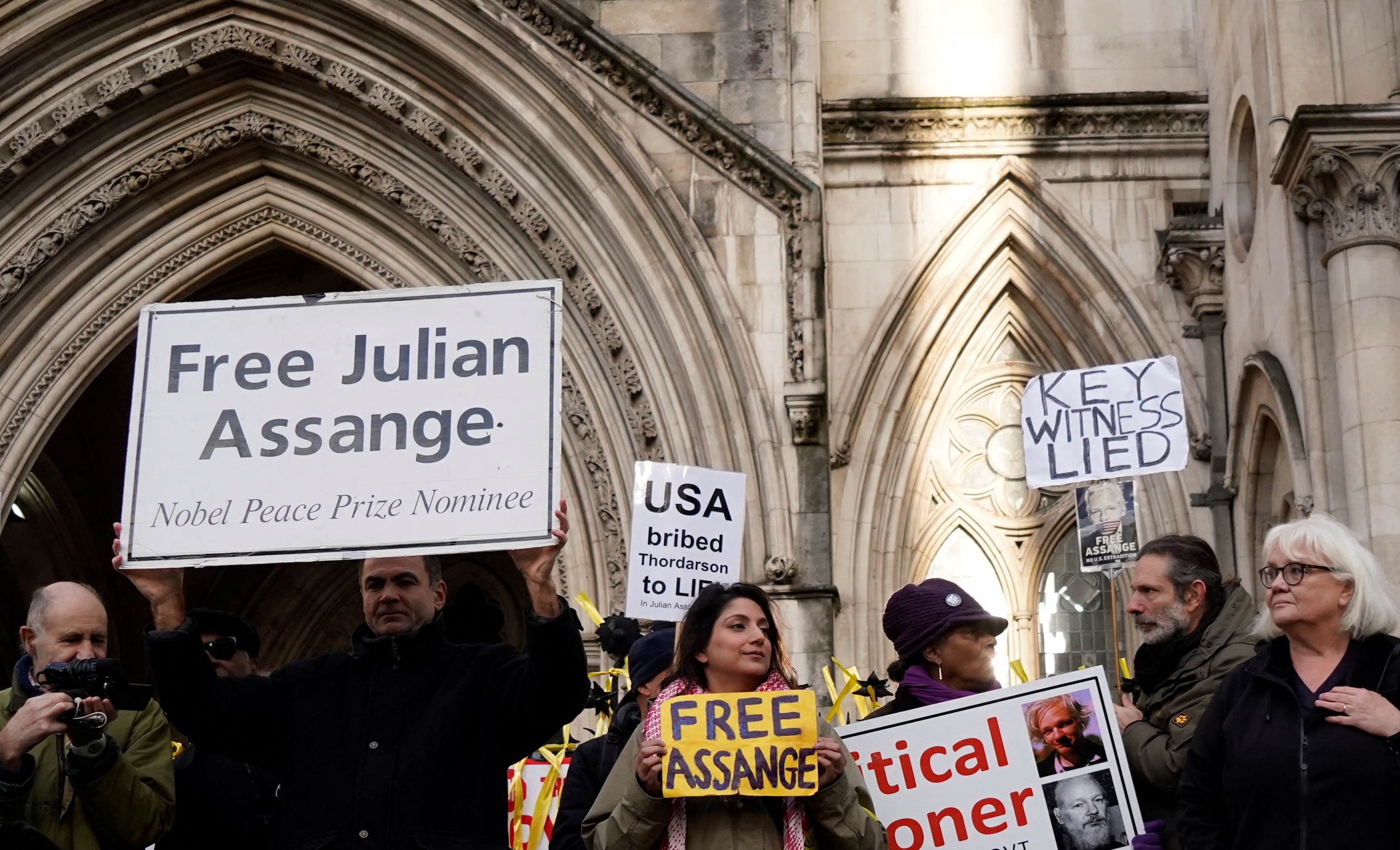 Los partidarios del fundador de WikiLeaks, Julian Assange, sostienen carteles frente a los Tribunales Reales de Justicia en Londres el 10 de diciembre de 2021. 