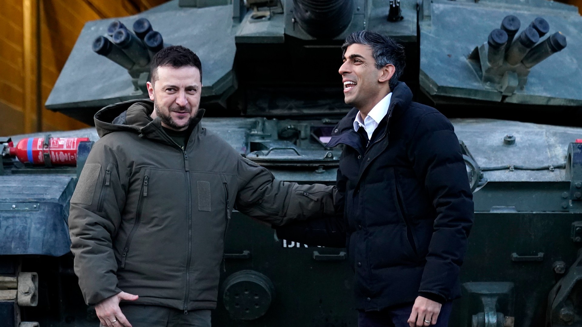 British Prime Minister Rishi Sunak, right, and Ukrainian President Volodymyr Zelensky meet Ukrainian troops being trained to command Challenger 2 tanks at a military facility in Lulworth, Dorset, England, Wednesday Feb. 8, 2023.