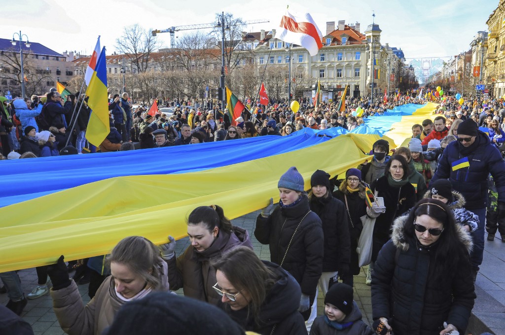 People hold Ukrainian flags to protest against Russia’s invasion of Ukraine in Vilnius, Lithuania, on 11 March 2022 (AFP)